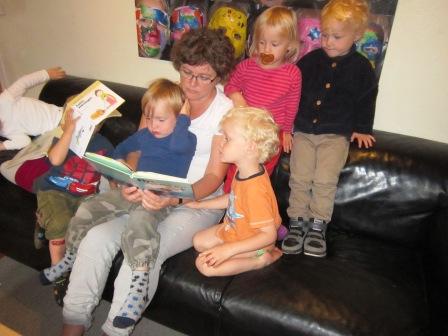 En voksen læser med børnene i vores stue
